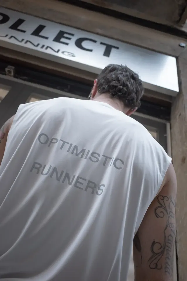 The back of a white shirt with the words Optimistic Runners