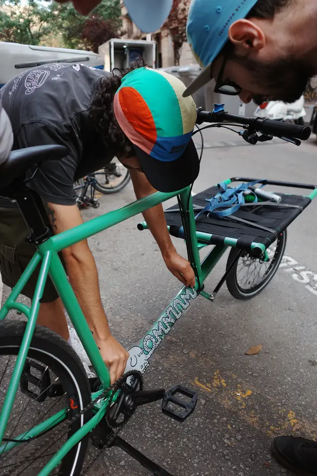 A person working on a green bicycle