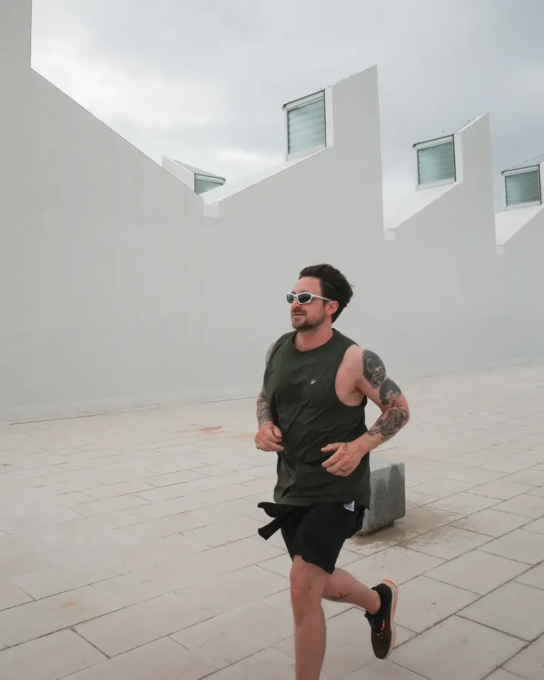 A runner passing a plain white wall