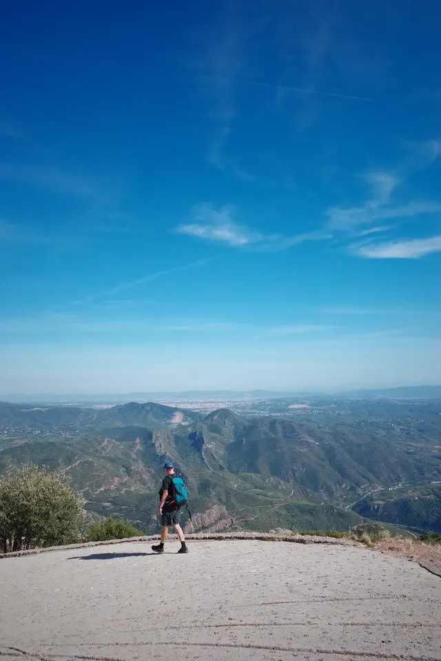 A person standing on a ridge above a wide valley